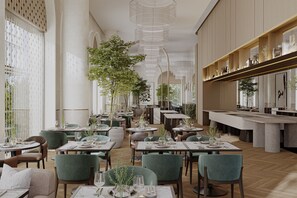 Un interior de restaurante moderno con varias mesas, sillas y una columna central con plantas.