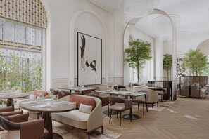 A modern dining area with round tables, cushioned seating, and a large abstract painting on the wall. - InterContinental Belgrade by IHG (New Belgrade)