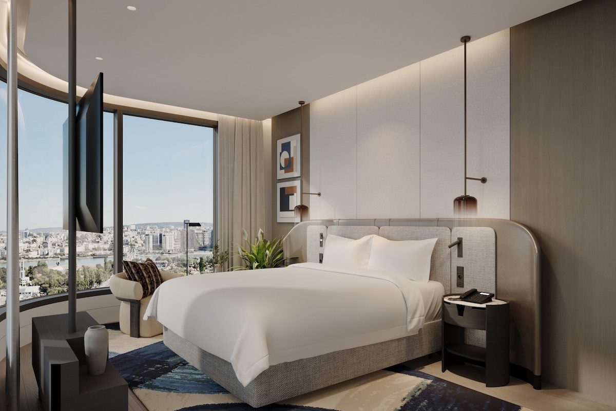 Un dormitorio moderno con una cama grande, vistas a la ciudad y decoración contemporánea.