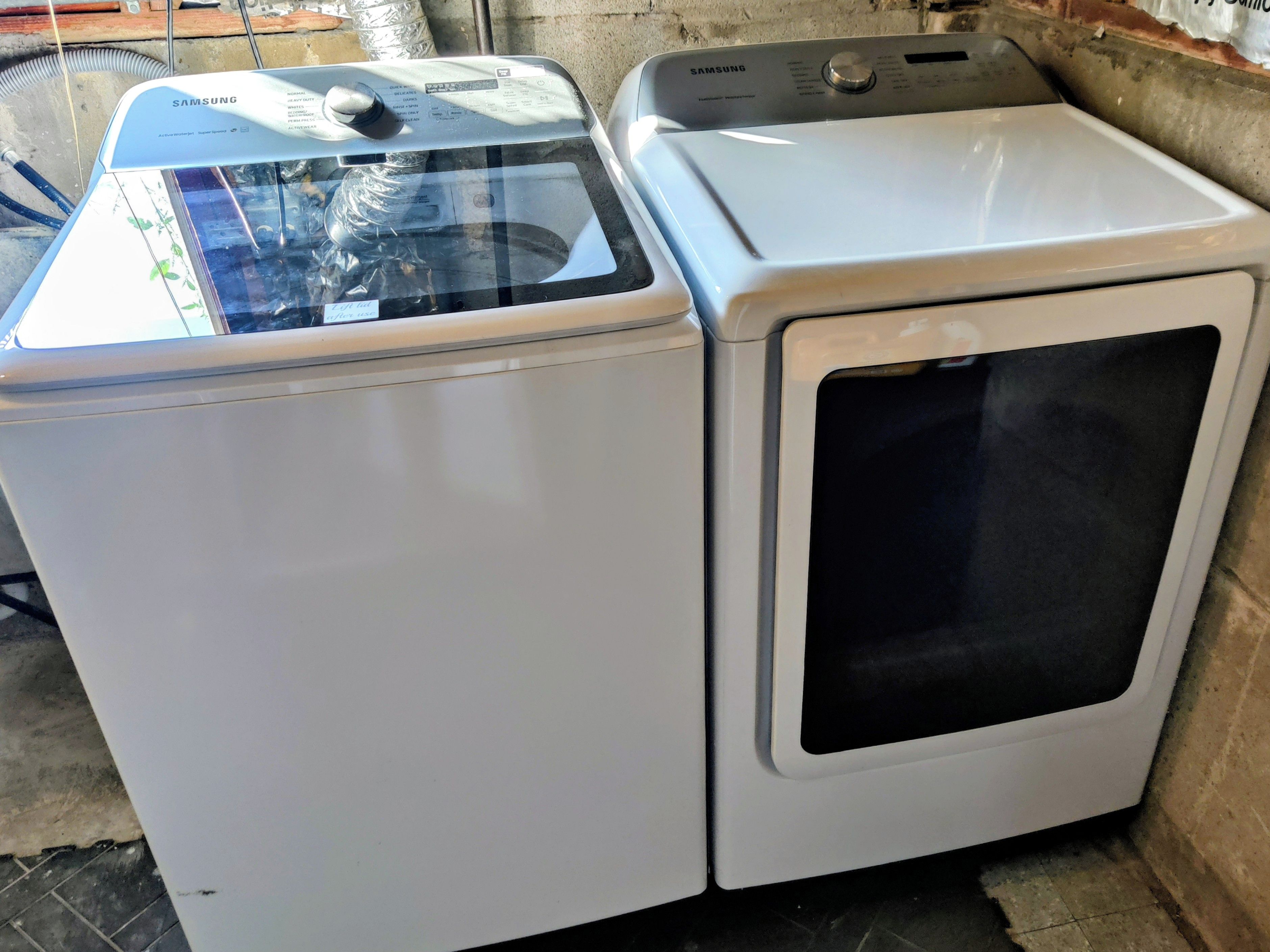 A Samsung washing machine and dryer side by side in a room.