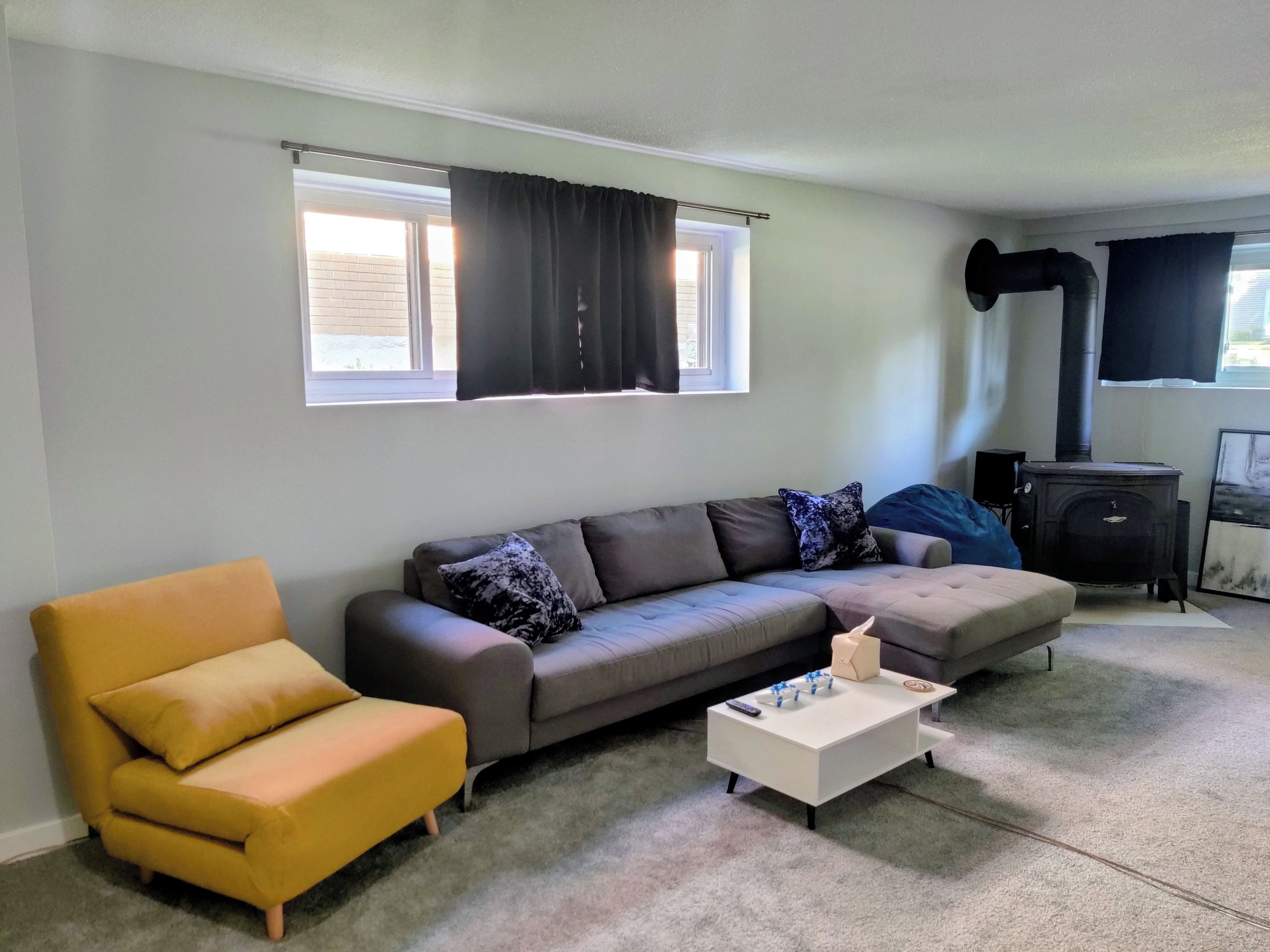 A living room with a sofa, armchair, and a white coffee table.