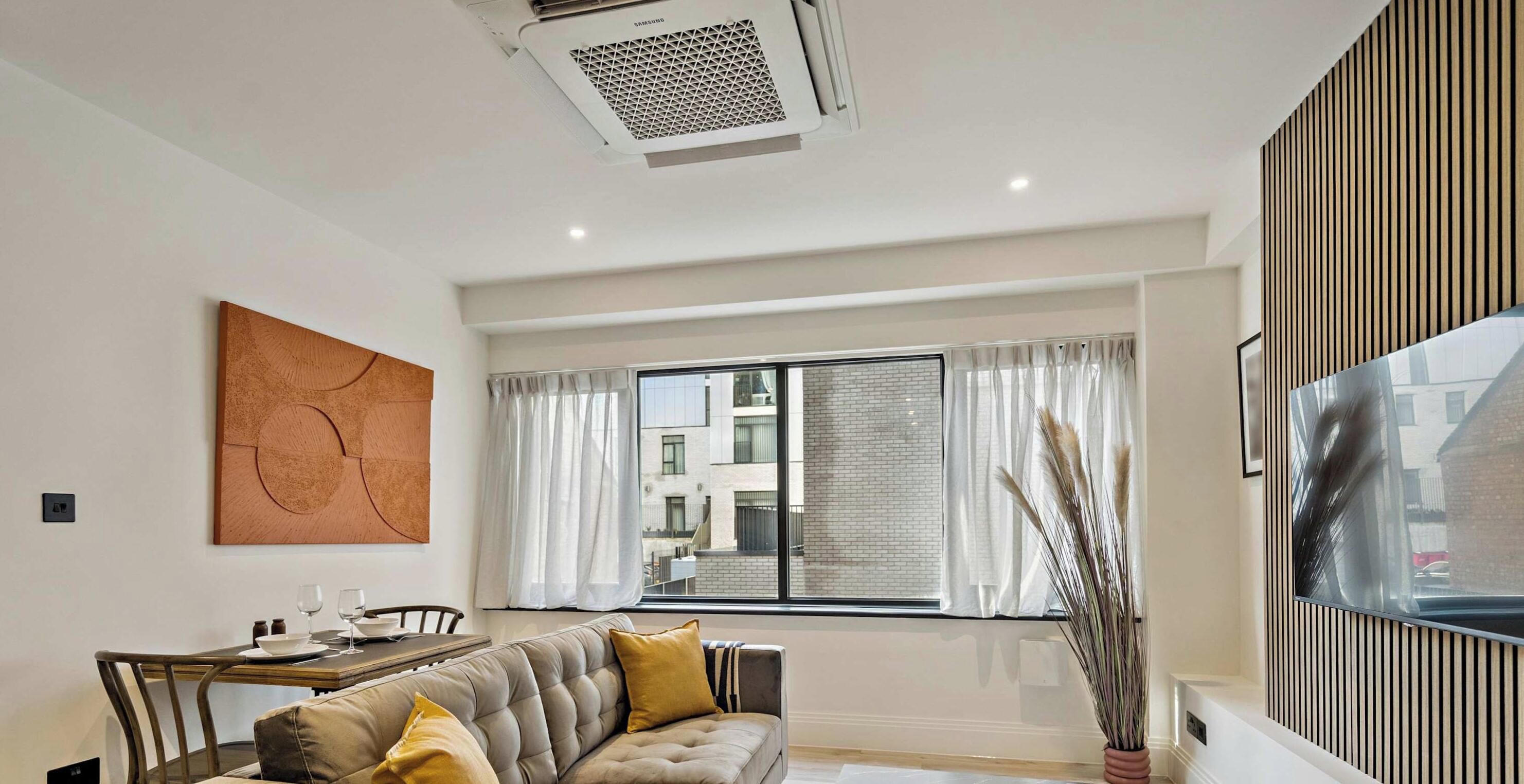 A modern living room with a sofa, dining table, and a large window.