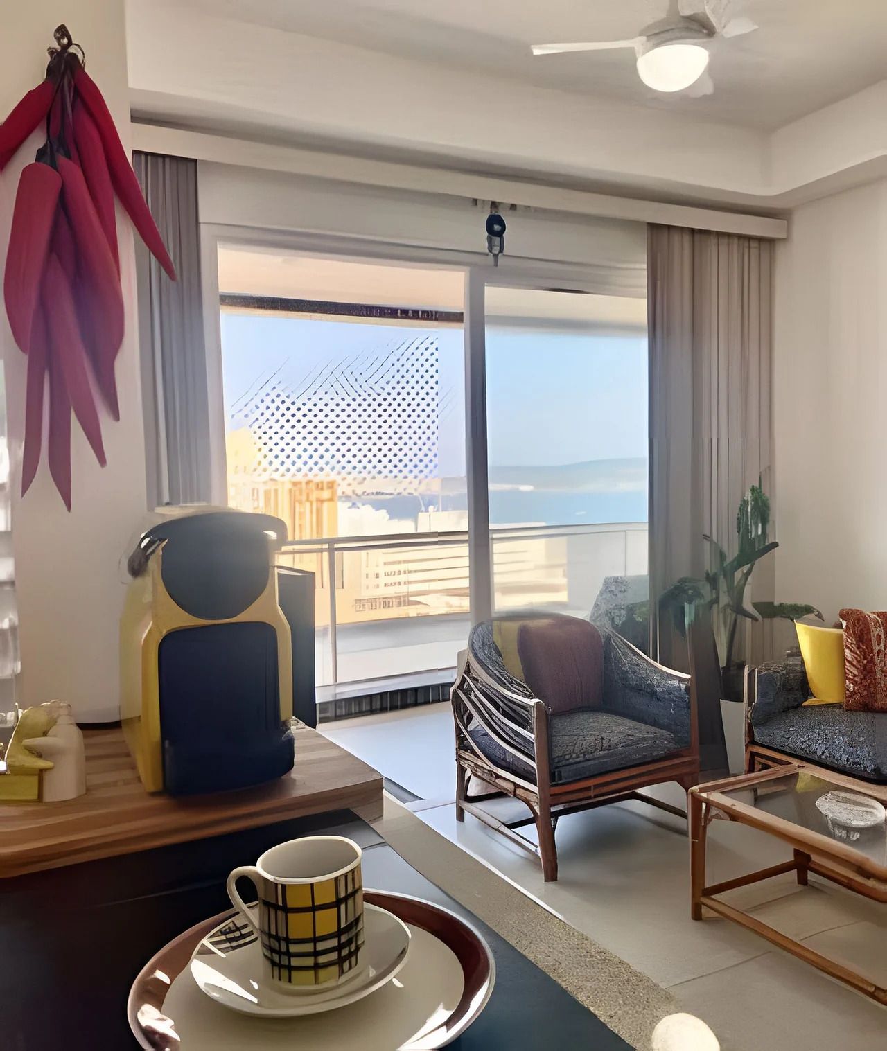 Sala de estar moderna com uma janela ampla, ventilador de teto e vista para o mar.