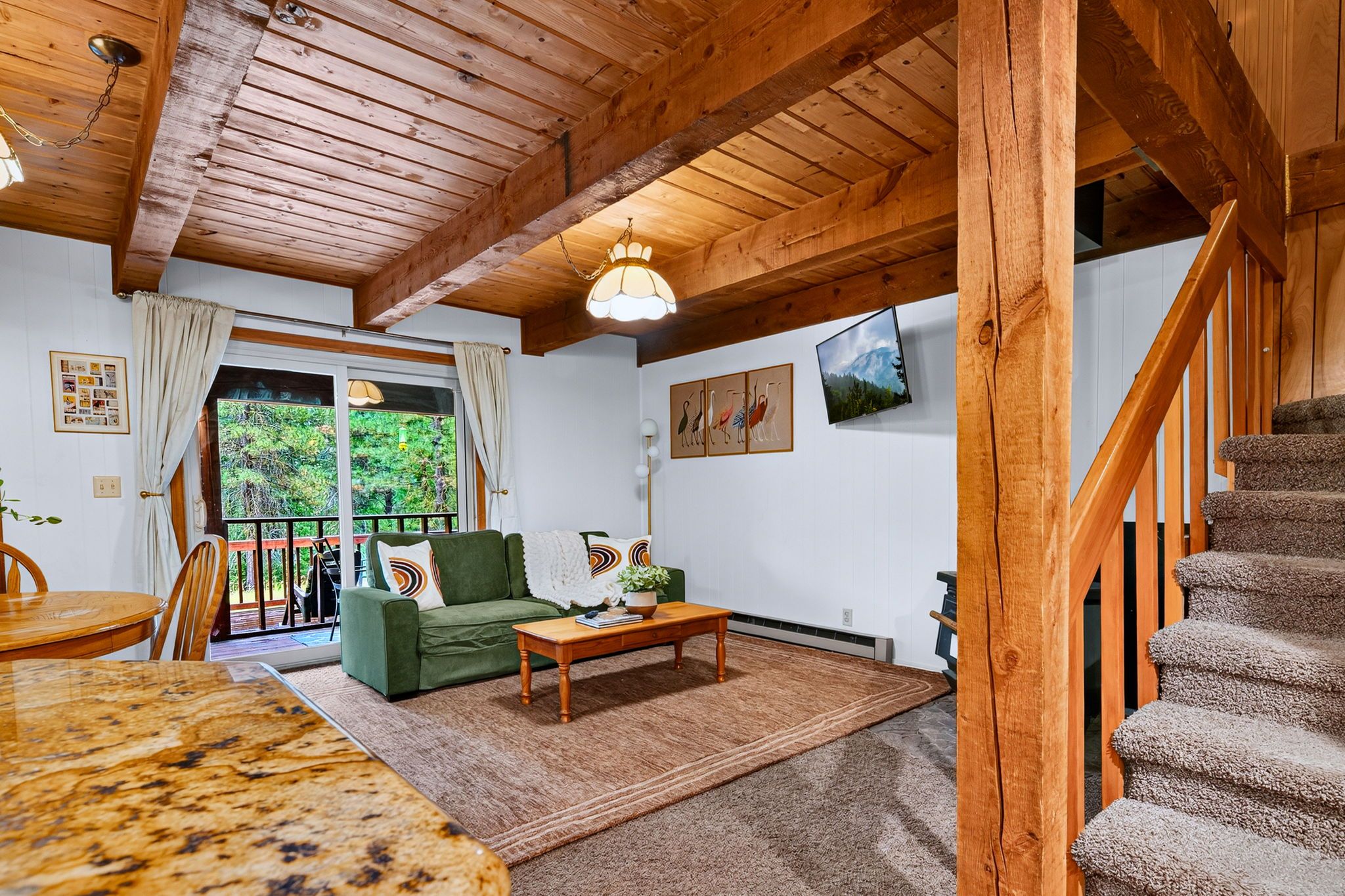 A wooden interior with a sofa, coffee table, and a staircase.