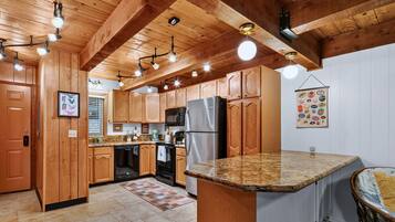 A kitchen with wooden cabinets, a granite countertop, and modern appliances.
