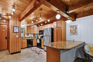 Une cuisine dotée de meubles en bois, d’un plan de travail en granit et d’appareils électroménagers modernes.