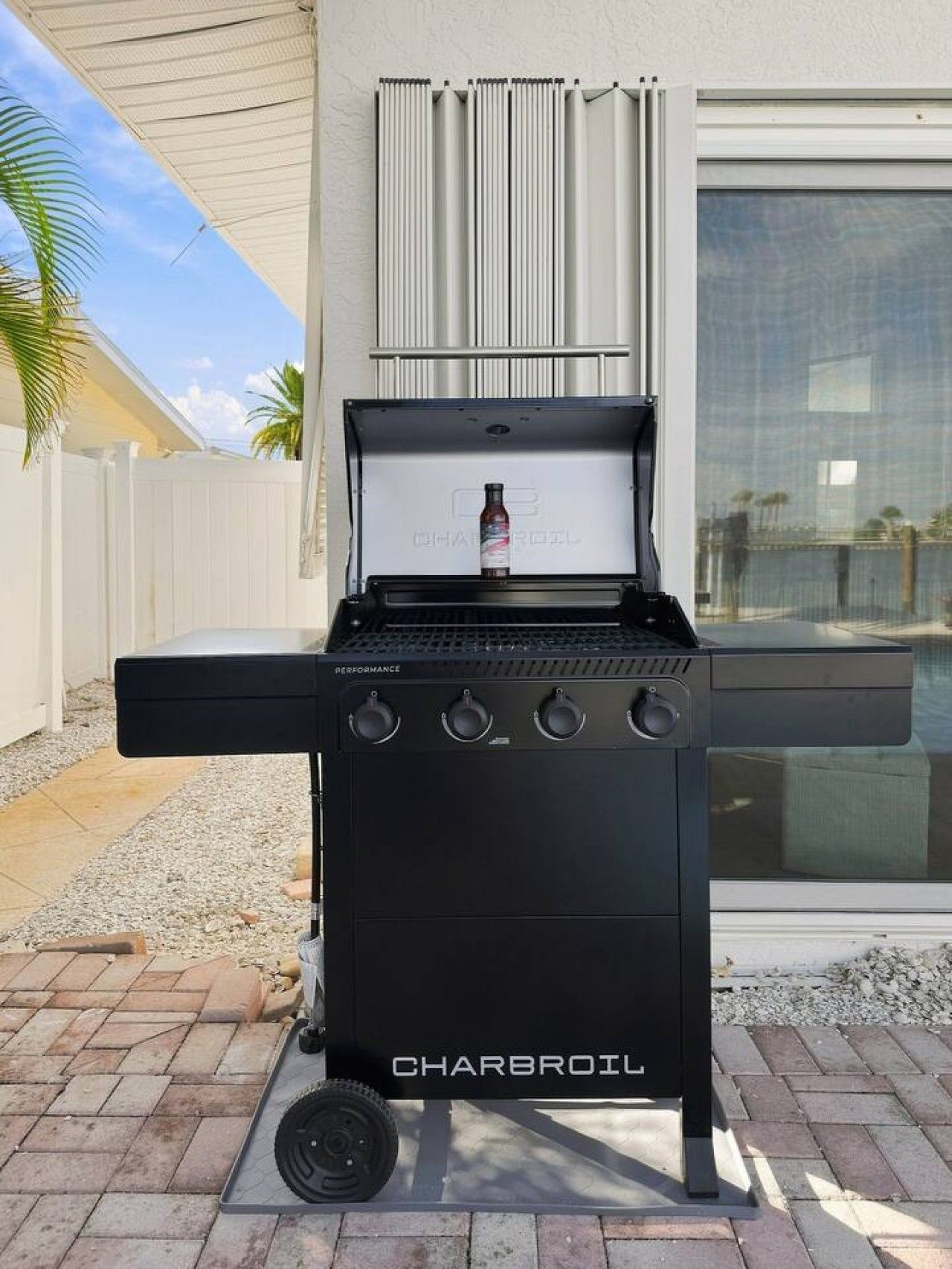 Un barbecue Charbroil doté de quatre boutons de réglage, d’une bouteille de combustible et d’un couvercle ventilé.