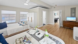 Una habitación con cama, escritorio, televisor y armario.