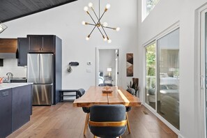 A modern kitchen with a central island, stainless steel appliances, and a contemporary light fixture. - Mountain Haus | 4BR | 3 Decks | Views | Fireplaces (Blue Ridge)