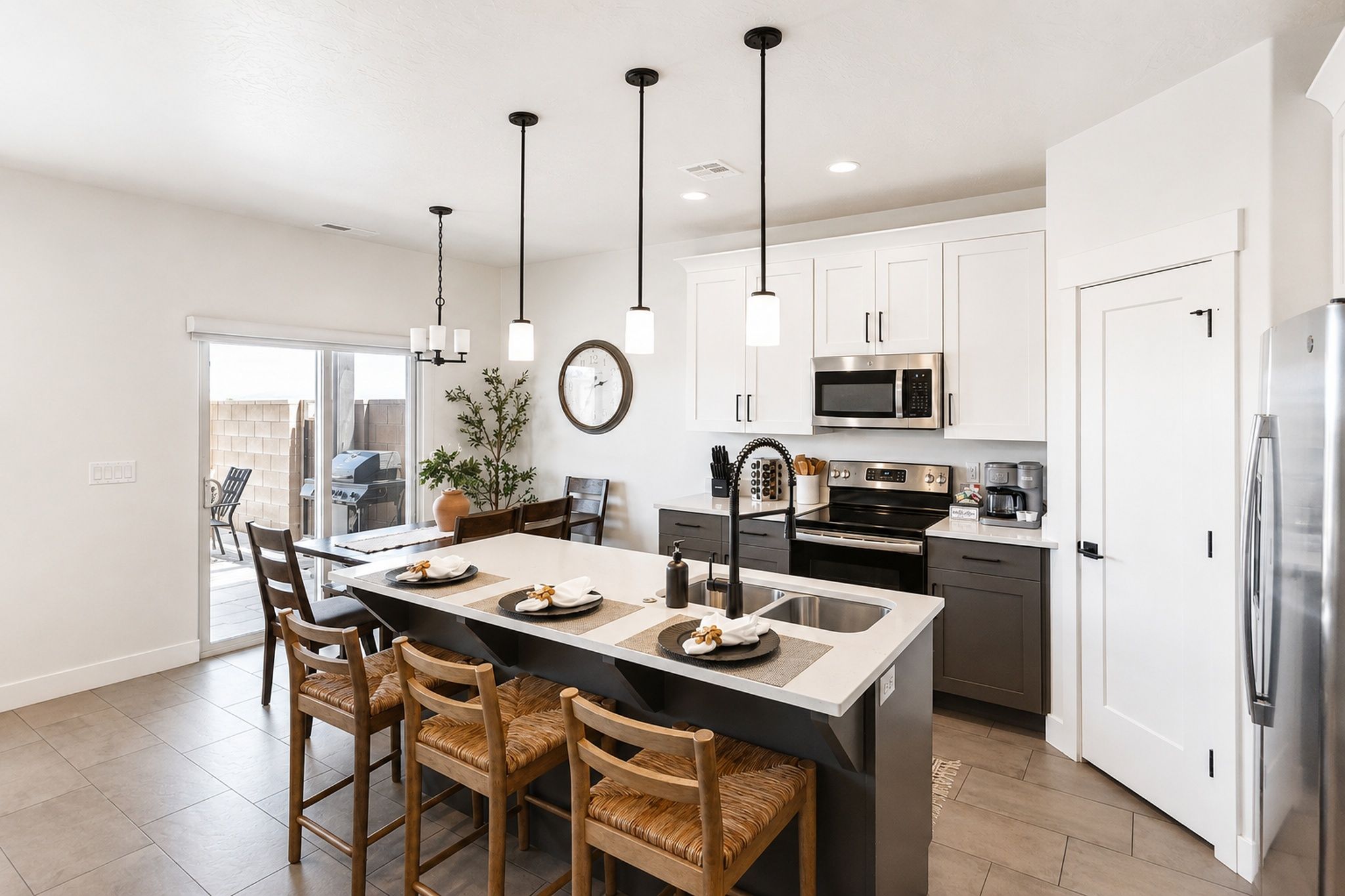 Una cocina moderna con una isla central, electrodomésticos de acero inoxidable y un comedor con sillas de madera.