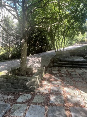 A paved pathway with stone slabs and a tree in a landscaped area. - Beautiful Private Forest Getaway in Peachtree Corners. (Peachtree Corners)