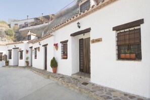 A row of white buildings with stone steps, potted plants, and a sign that reads 'La Mina'. - La Mina Cave House in Castilléjar (Castilléjar)