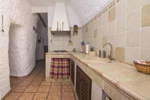 A kitchen with a tiled backsplash, a sink, and a countertop.