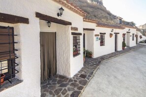 A row of white buildings with stone foundations, wooden doors, and black window bars.