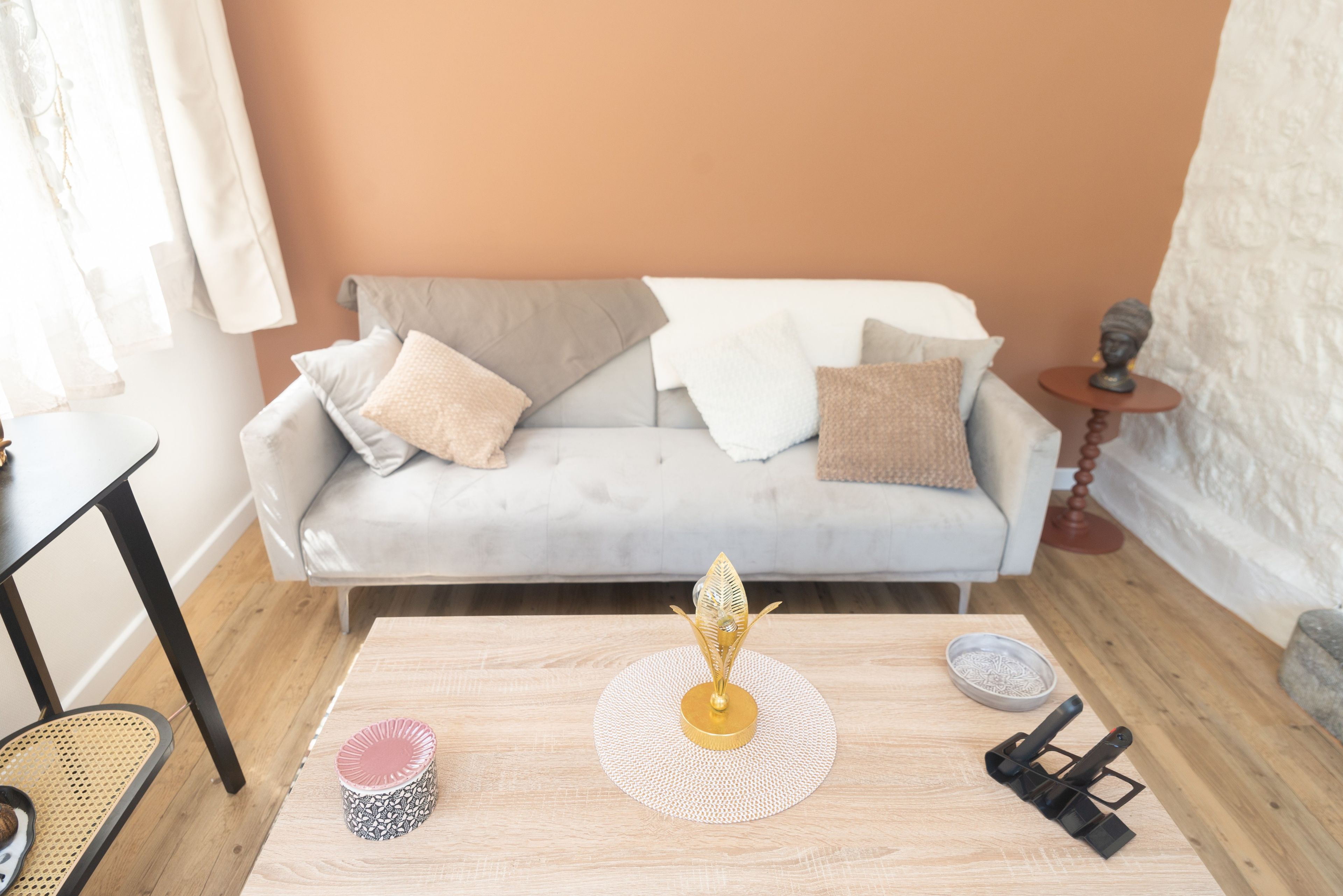 Een woonkamer met een bank, een salontafel en een bijzettafeltje.