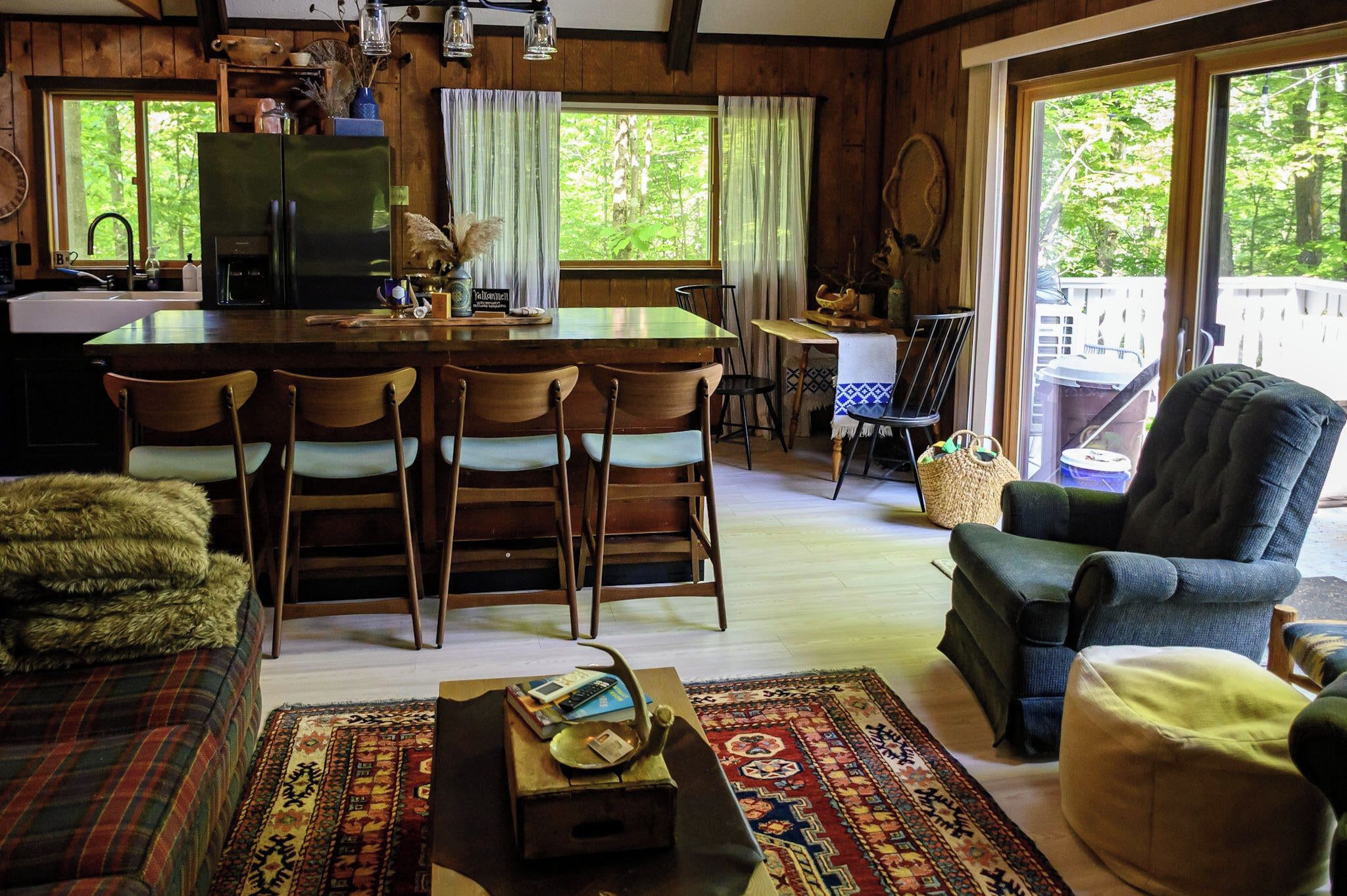 A cozy cabin interior with a dining area, kitchen, and seating space.
