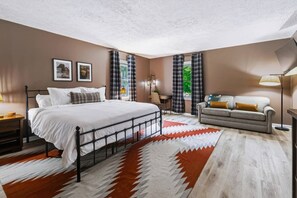 A bedroom with a bed, a sofa, a desk, and a window with curtains. - Shepard`s Lodge - families and pets welcome! (Indianapolis)