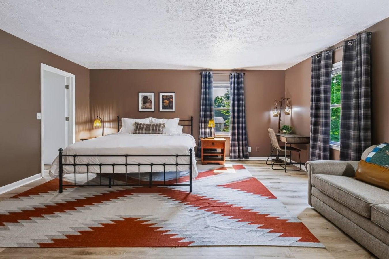 Une chambre à coucher avec un lit, un bureau et un canapé.
