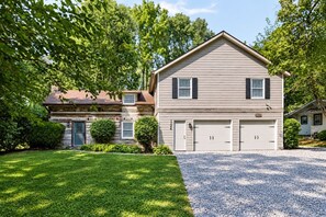 A two-story house with a garage, surrounded by a well-maintained lawn and trees. - Shepard`s Lodge - families and pets welcome! (Indianapolis)