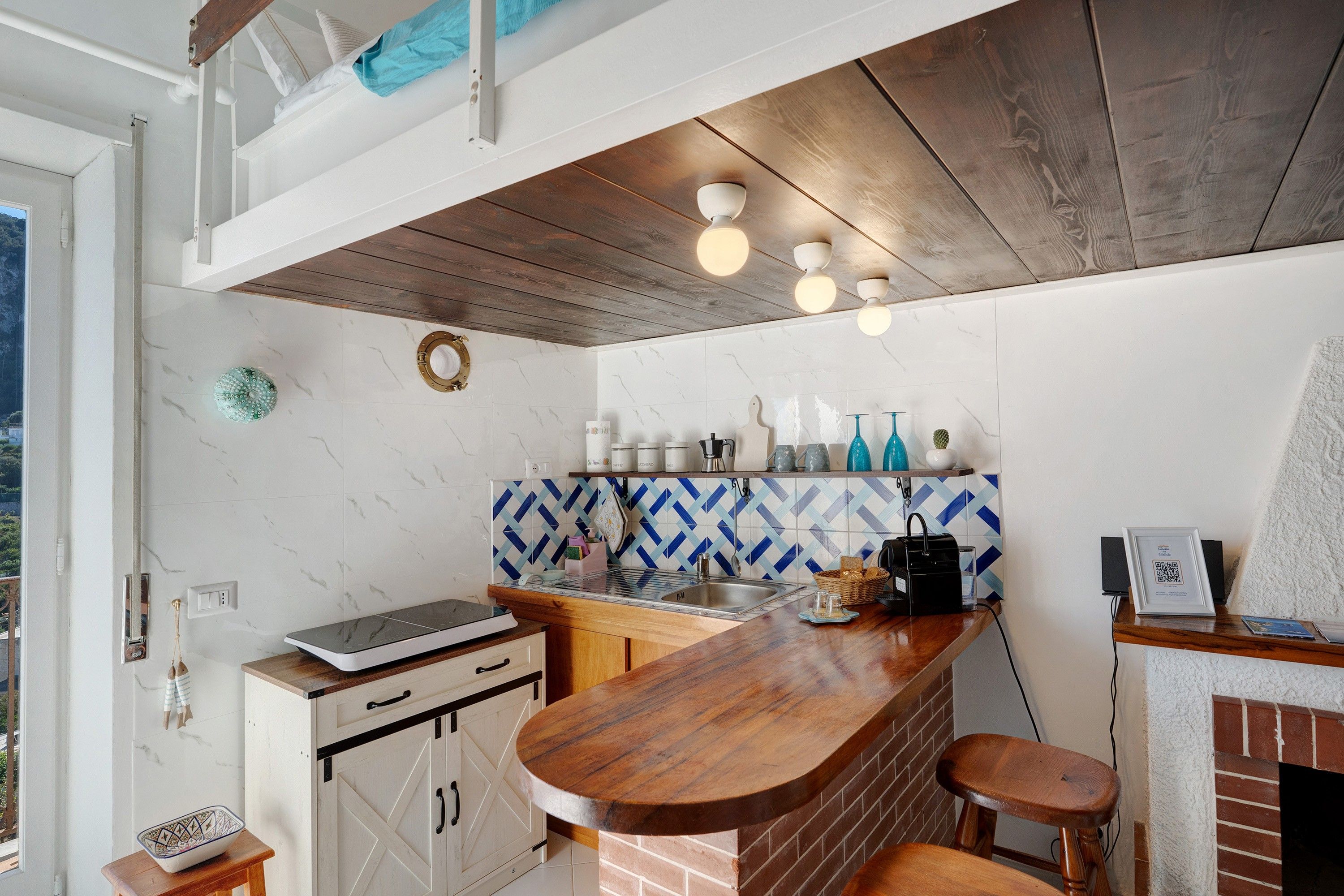 A kitchen with a wooden countertop, a brick backsplash, and a hanging light fixture.
