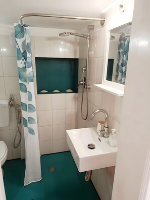 A bathroom with a shower, toilet, sink, and a mirror. - Casetta del Custode with sea view, Wi-Fi, and air conditioning (Capri)