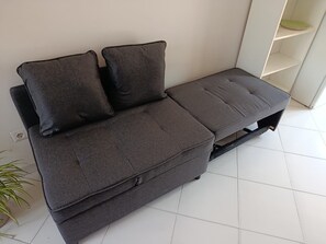A grey sofa with two cushions and a matching ottoman in a room with white tiled flooring. - Casetta del Custode with sea view, Wi-Fi, and air conditioning (Capri)