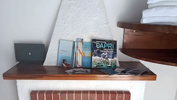 A fireplace with a brick design, a white mantel, and a stack of books on top.