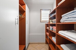 A walk-in closet with wooden shelving, a window, and a tiled floor. - Villa Atoumo lounge - Four Bedroom Villa, Sleeps 8 (Sainte-Luce)