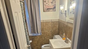 Ein Badezimmer mit Toilette, Waschbecken und Duschbereich.