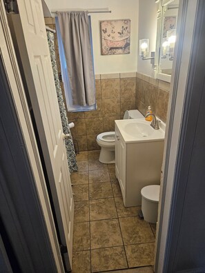 Ein Badezimmer mit Toilette, Waschbecken und Duschbereich.