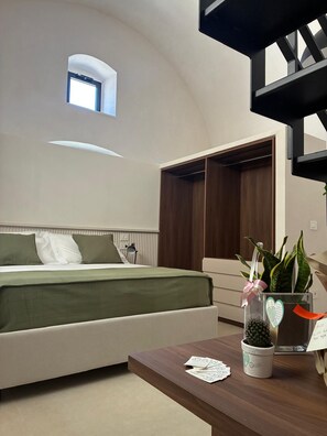 A bedroom with a bed, bedside table, and a window.