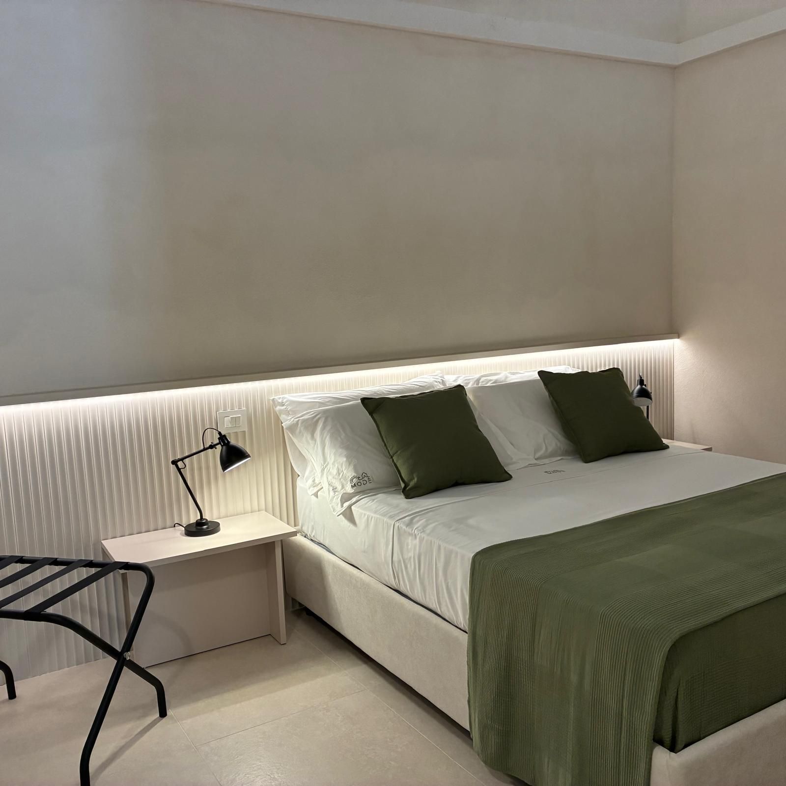 Une chambre à coucher avec un lit, des tables de chevet et une lampe.