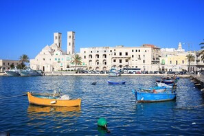 A harbor with boats, a prominent building with towers, and a clear blue sky.
