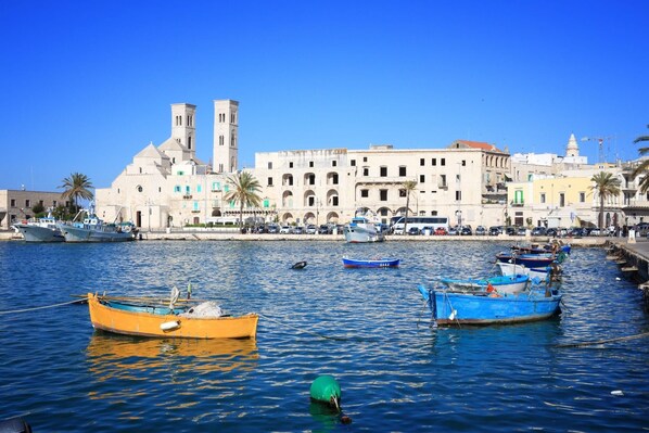A harbor with boats, a prominent building with towers, and a clear blue sky.