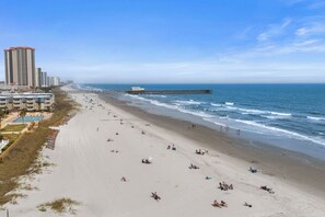 A beach with a pier extending into the ocean, surrounded by high-rise buildings. - Heavenly Sunsets by the beach! (Myrtle Beach)
