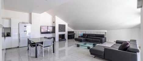 Un espacio moderno para vivir con comedor, sofá y televisión de pantalla plana.