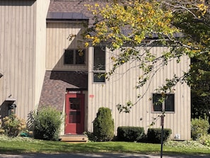 A two-story building with a red door labeled 'DONAHUE' and a small front yard with a lawn and shrubs. - Nestled on Haystack Mountain and golf course, just 5 miles from Mount Snow! (Wilmington)