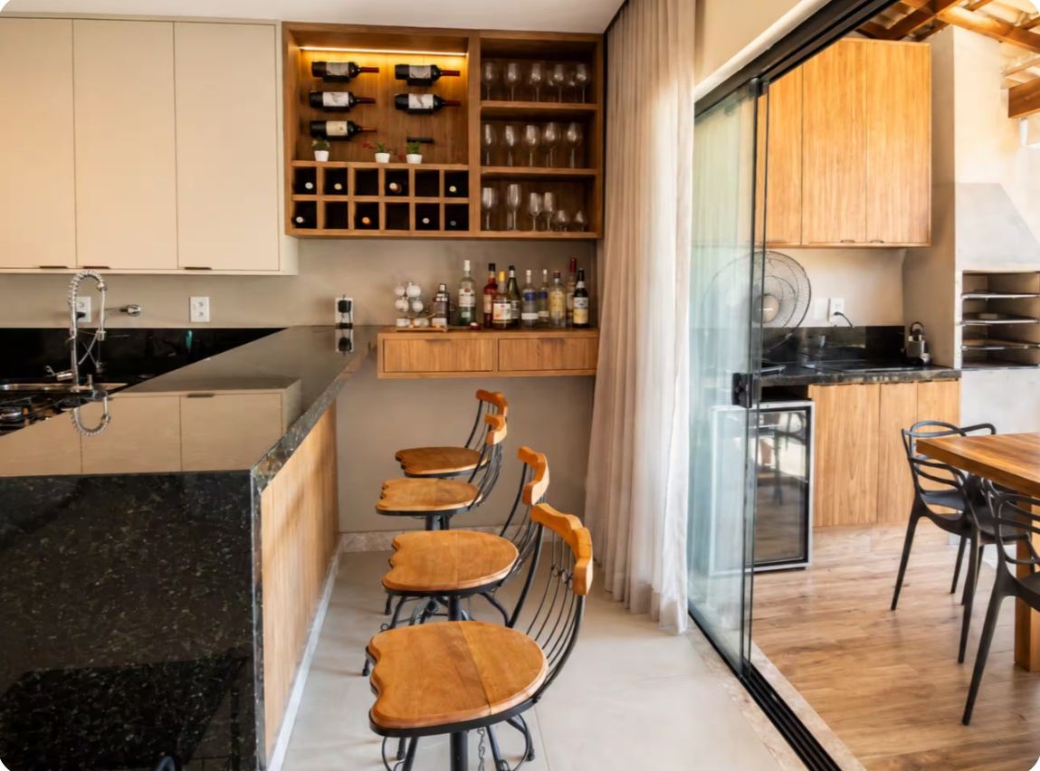 Een moderne keuken met een centraal eiland, houten kastjes en een wijnrek.