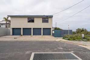 Un bâtiment à deux étages, doté d’un toit plat, de trois portes de garage et d’une entrée fermée par un portail.