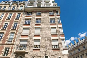 A multi-story building with a stone facade, multiple windows, and balconies. - Parisian Residence Near Notre-Dame on Île de la Cité (Paris)