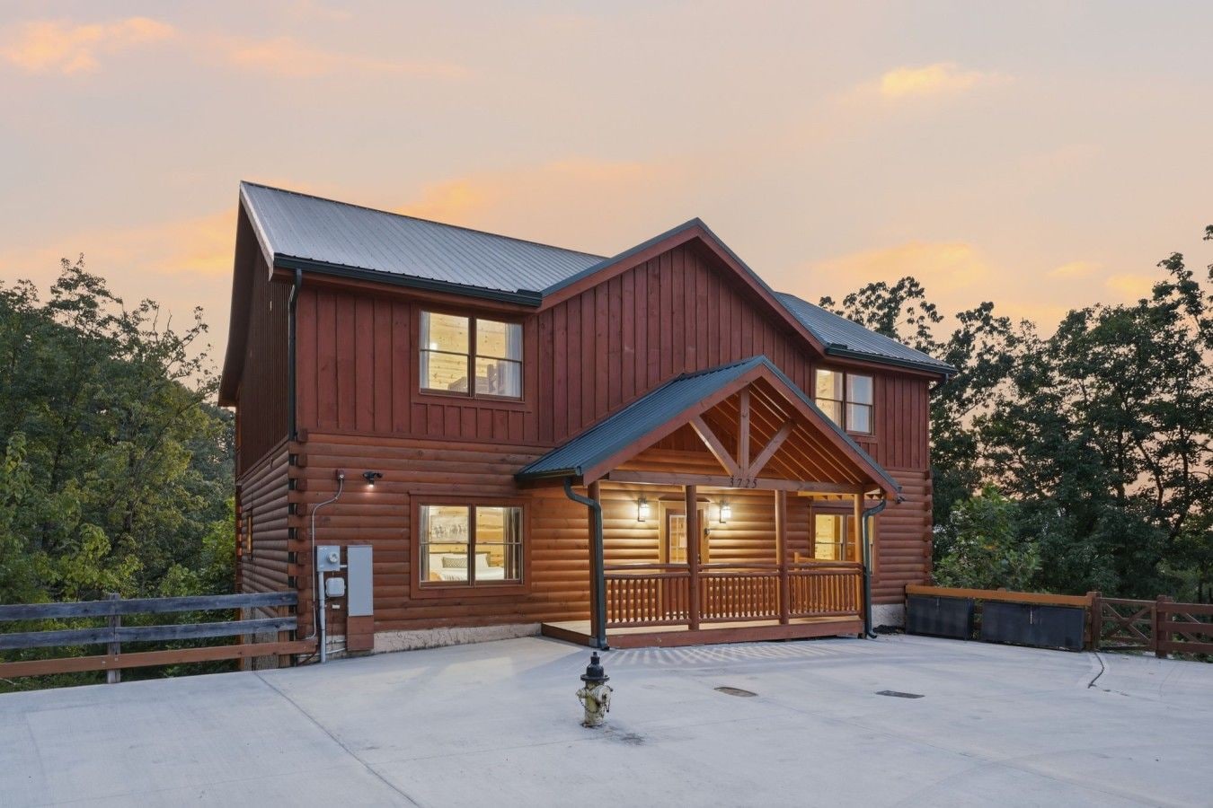 A two-story log cabin with a porch and a covered entryway.