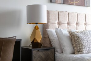Ein Schlafzimmer mit einem Bett, einem Nachttisch und einer Lampe.