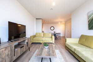 A modern living room with a sofa, a coffee table, and a TV. - Birmingham City Retreat No 154 (Birmingham)