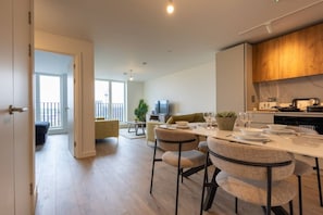 A modern apartment with a dining area, kitchen, and a balcony with a view. - Birmingham City Retreat No 154 (Birmingham)