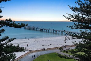 A pier extending into calm waters with a clear sky above. - Glenelg Bliss Charming Escape for Beachside Fun (Glenelg)