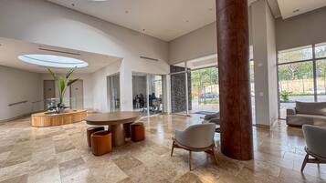 A spacious lobby with a round wooden table, seating, and a large pillar.