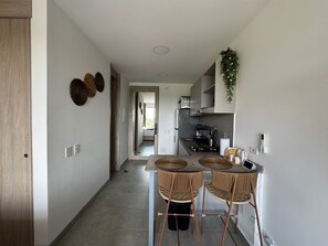 A modern kitchen with a central island, stainless steel appliances, and a hanging plant. - Suite santa marta 614 - T1 (Santa Marta)
