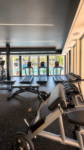 A gym with treadmills, weight benches, and dumbbells. - Upscale Playacar Studio w Beach Club & 4 Pools (Playa del Carmen)