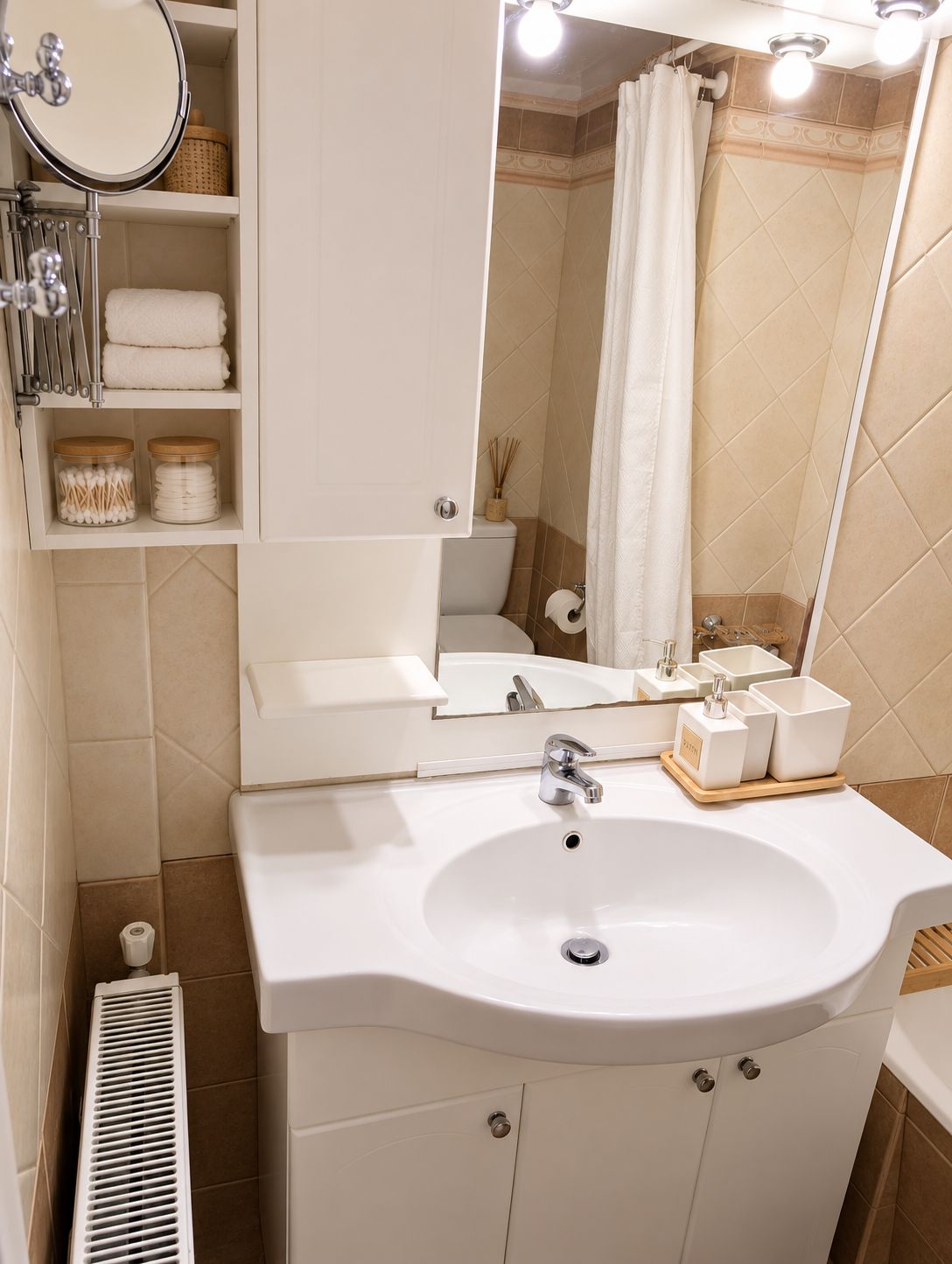 A bathroom with a white sink, mirror, and towel rack.