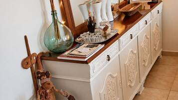 A white cabinet with decorative items, a mirror, and two lamps.